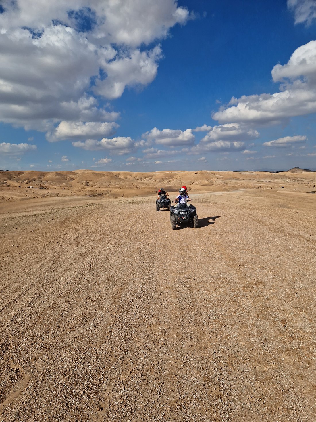 Two riders on a guided quad biking trail in the rocky Agafay desert near Marrakech